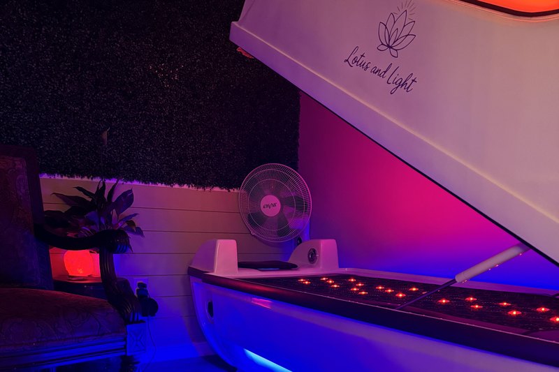 The NOVA 2 full-body red light bed, open and lit, at Lotus and Light